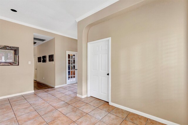 unfurnished room with baseboards, ornamental molding, and light tile patterned flooring