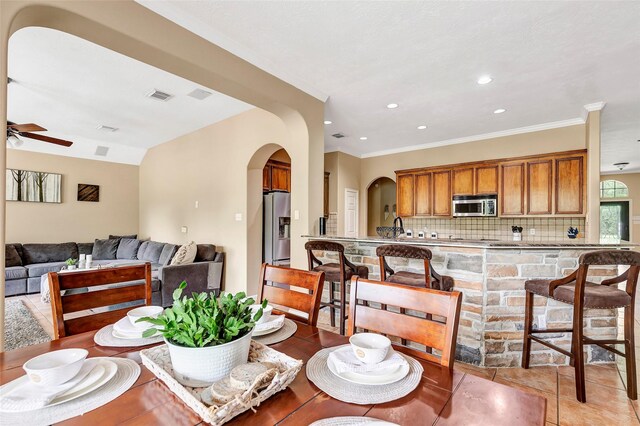 dining area with a ceiling fan, arched walkways, ornamental molding, visible vents, and recessed lighting