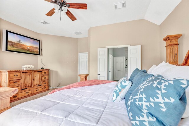 carpeted bedroom featuring vaulted ceiling, visible vents, and a ceiling fan