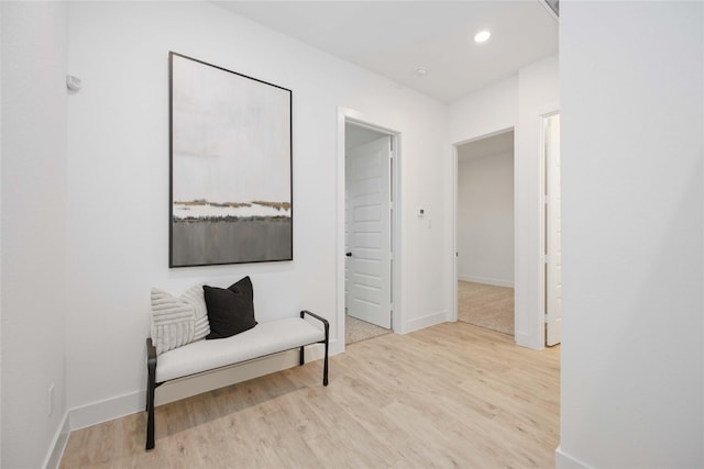 living area with baseboards, wood finished floors, and recessed lighting
