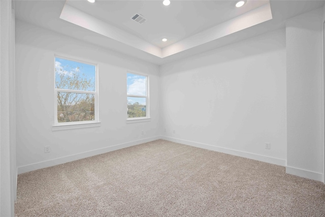 carpeted empty room with baseboards, visible vents, recessed lighting, and a tray ceiling