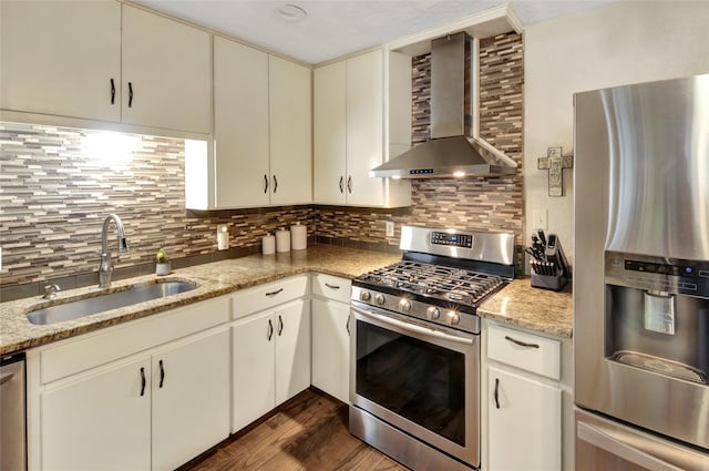 kitchen with a sink, dark wood-style flooring, tasteful backsplash, wall chimney range hood, and appliances with stainless steel finishes