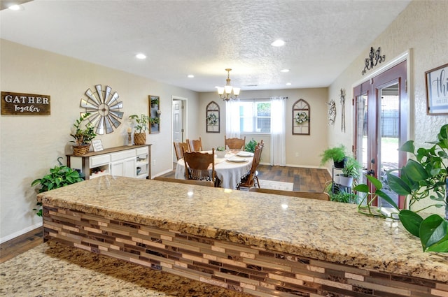 dining room featuring a notable chandelier, baseboards, and dark wood-style flooring