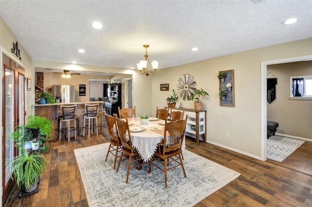 dining room featuring a textured ceiling, dark wood-style flooring, baseboards, recessed lighting, and a notable chandelier