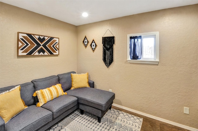 living area featuring baseboards and a textured wall