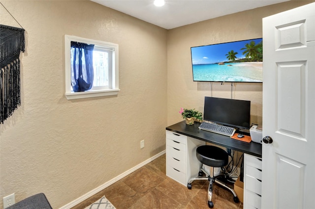 office area with a textured wall and baseboards
