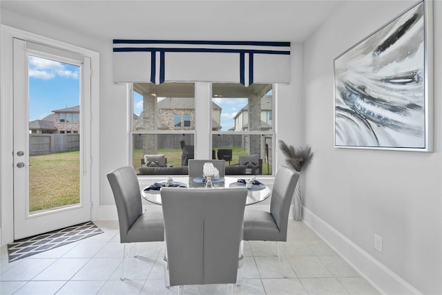 dining space with light tile patterned floors and baseboards
