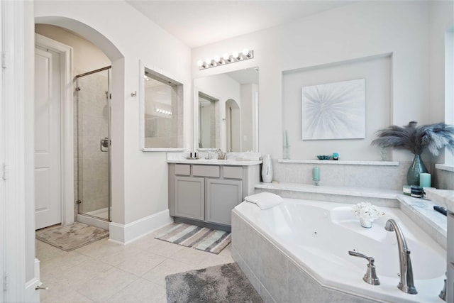 full bathroom featuring tile patterned flooring, vanity, baseboards, a tub with jets, and a shower stall