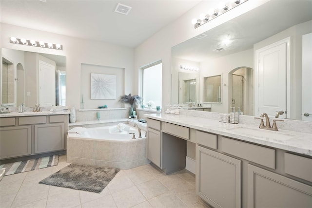 full bathroom featuring a sink, tile patterned flooring, visible vents, a garden tub, and a stall shower
