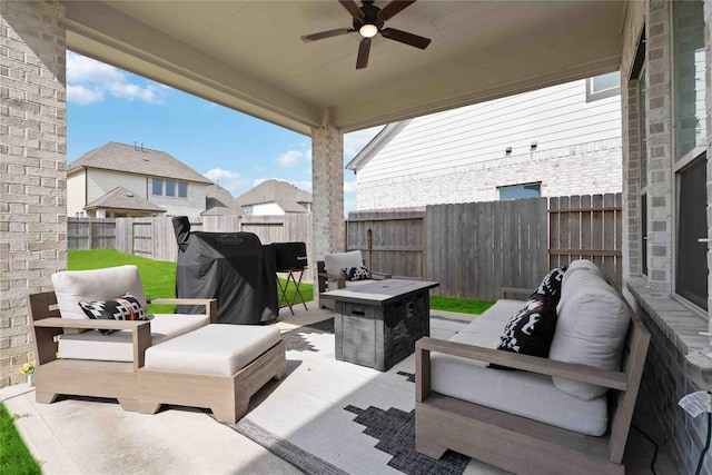 view of patio with a fenced backyard, an outdoor living space with a fire pit, and a ceiling fan