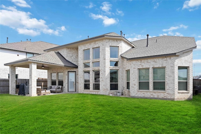 rear view of property featuring fence, roof with shingles, an outdoor living space, a ceiling fan, and a lawn