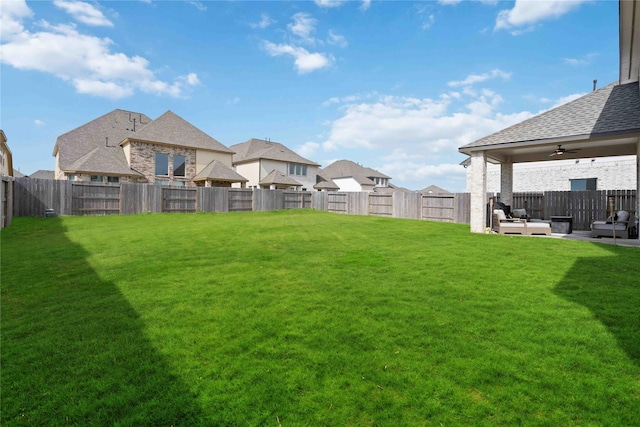view of yard featuring a patio, a fenced backyard, ceiling fan, and a residential view