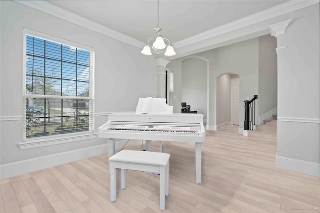 living area featuring baseboards, arched walkways, light wood finished floors, and crown molding