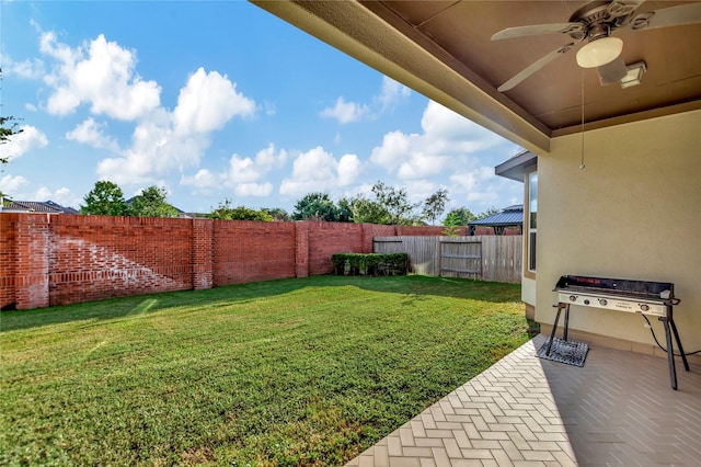 view of yard featuring a fenced backyard, a ceiling fan, and a patio