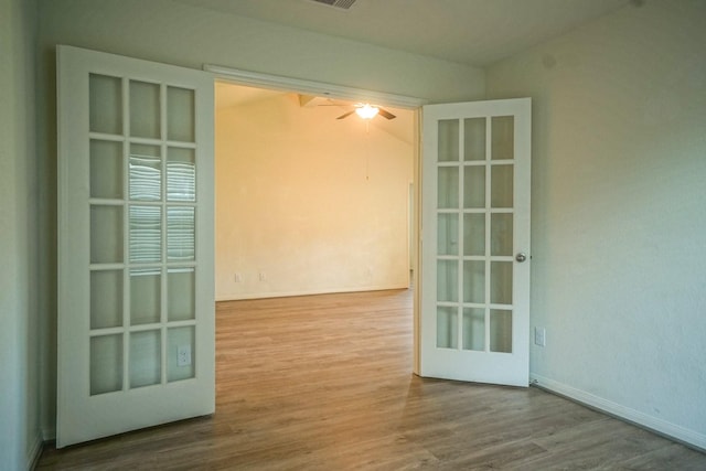 spare room with wood finished floors, ceiling fan, and baseboards
