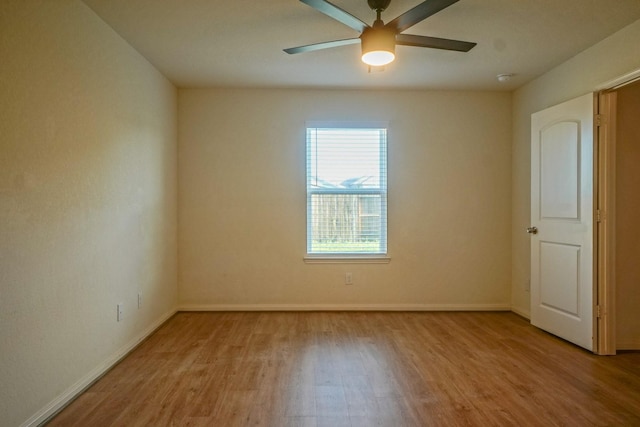 empty room with wood finished floors, ceiling fan, and baseboards