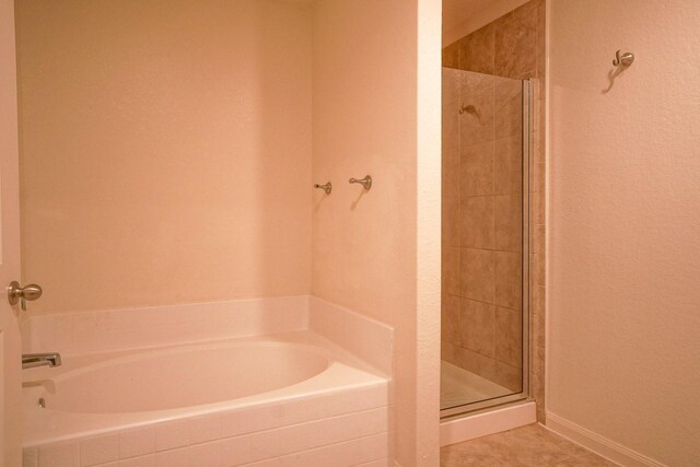 full bath with a stall shower and a garden tub