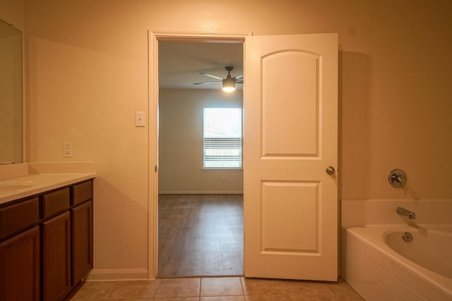 full bath featuring a bath, vanity, tile patterned flooring, ceiling fan, and baseboards