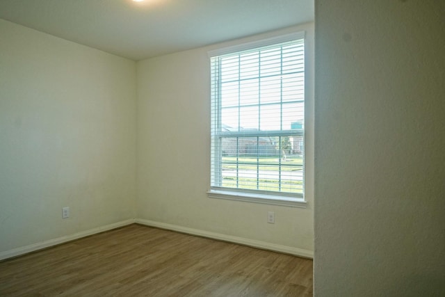 empty room featuring wood finished floors and baseboards