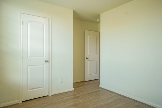 unfurnished bedroom with wood finished floors and baseboards