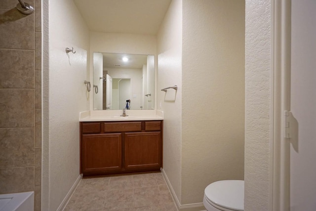 bathroom with toilet, vanity, tile patterned flooring, and baseboards