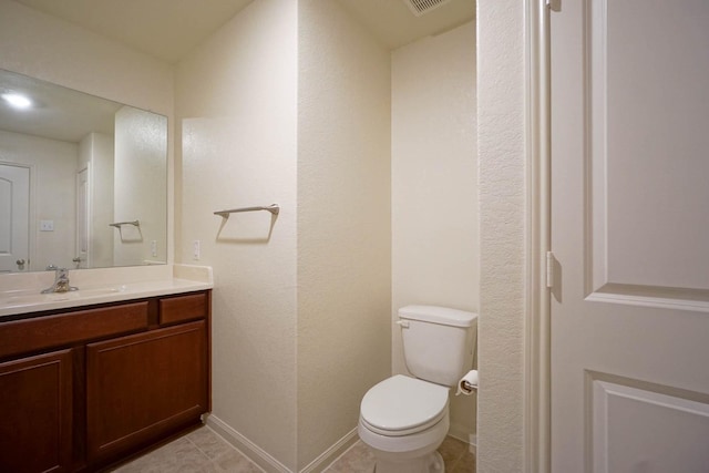 half bath with vanity, toilet, and baseboards