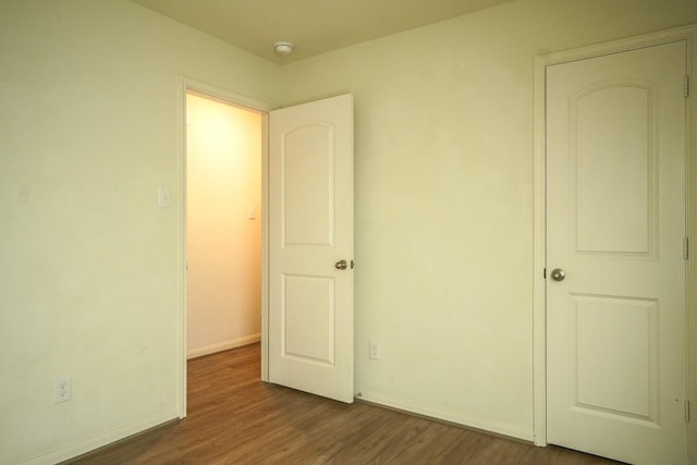unfurnished bedroom with dark wood finished floors and baseboards