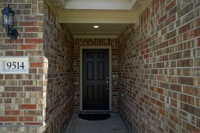 entrance to property featuring brick siding