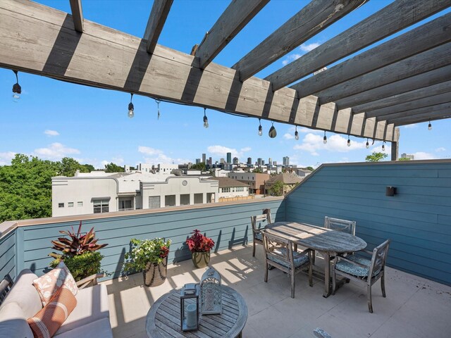 view of patio featuring outdoor dining space, a balcony, a city view, and a pergola