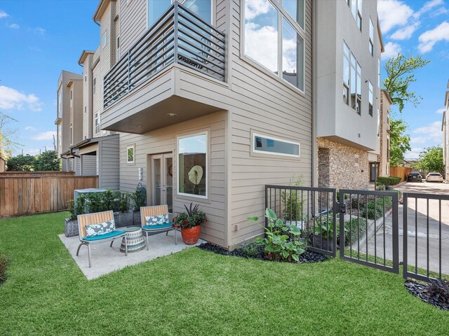 rear view of property featuring a yard, a patio area, and fence
