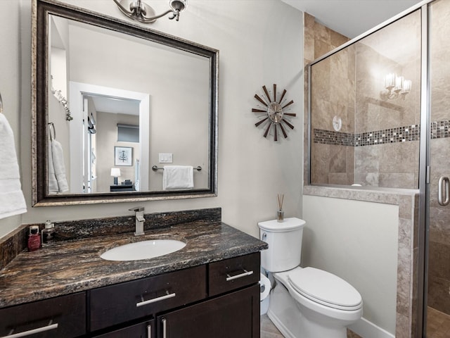 full bath with toilet, vanity, and a stall shower