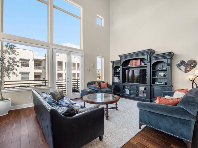 living room with baseboards, dark wood finished floors, and a high ceiling