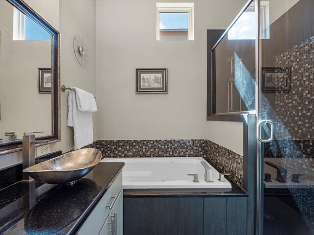 full bathroom featuring a garden tub, a stall shower, vanity, and plenty of natural light