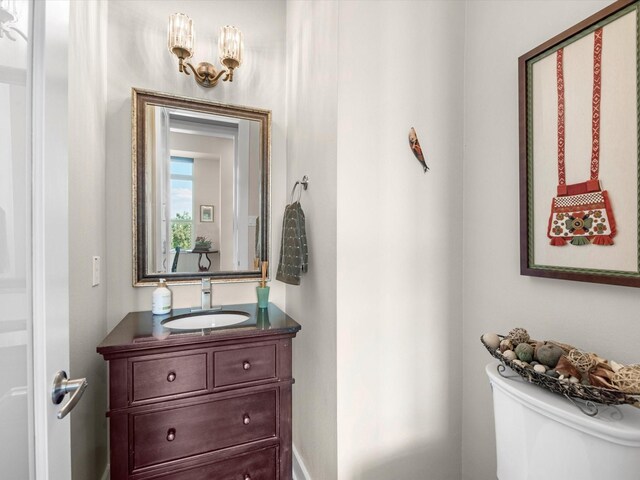 half bathroom with vanity and toilet