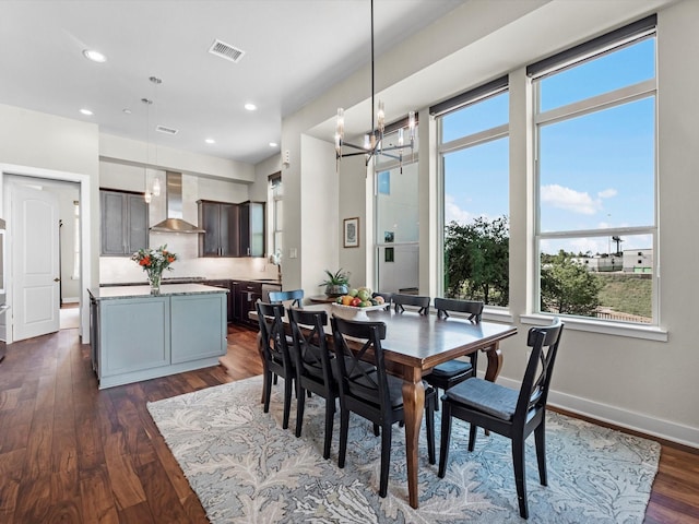 dining space with dark wood-style flooring, visible vents, an inviting chandelier, and a healthy amount of sunlight
