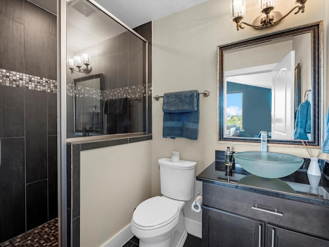 full bathroom with tiled shower, toilet, vanity, baseboards, and visible vents