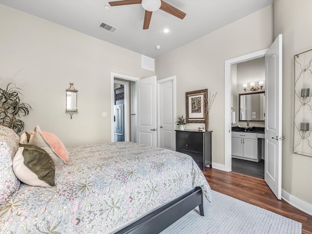 bedroom featuring dark wood-style floors, high quality fridge, visible vents, baseboards, and ensuite bathroom