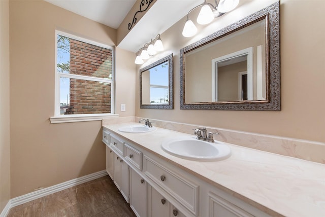 bathroom featuring a wealth of natural light, baseboards, a sink, and double vanity