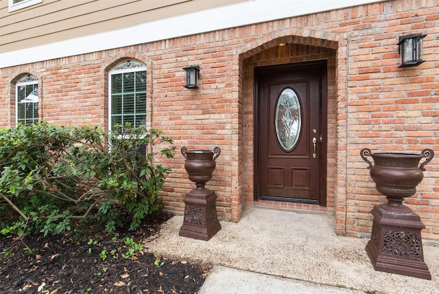 view of exterior entry featuring brick siding