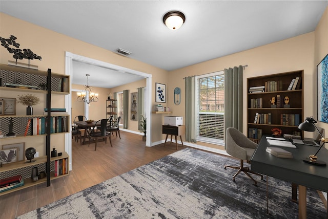 office area with visible vents, baseboards, wood finished floors, and an inviting chandelier