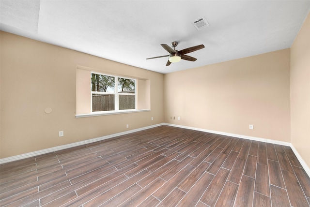 unfurnished room featuring dark wood-style flooring, a ceiling fan, visible vents, and baseboards