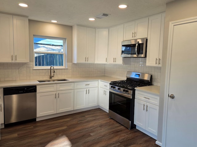 1403 Hitherfield Dr, Sugar Land, TX 77498 - kitchen featuring appliances with stainless steel finishes, a sink, white cabinetry, light countertops, and recessed lighting