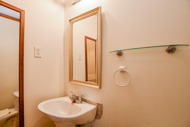 half bath featuring toilet and a sink