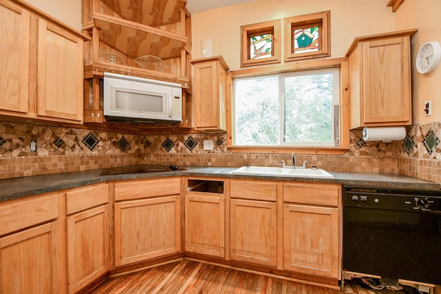 kitchen featuring light brown cabinets, black appliances, dark countertops, and a sink
