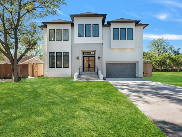 contemporary house featuring fence, stucco siding, driveway, a front yard, and a garage