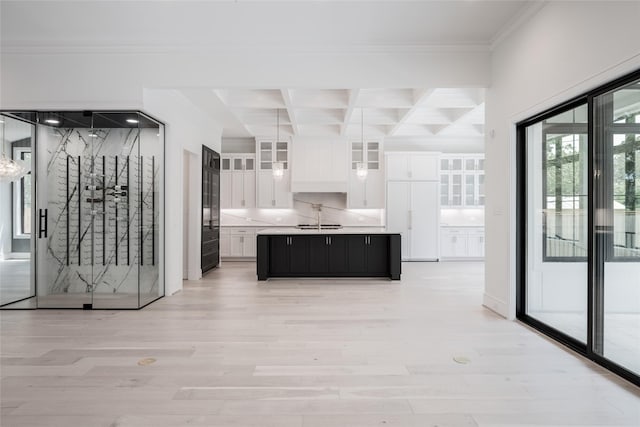 interior space featuring crown molding, light countertops, coffered ceiling, white cabinetry, and beam ceiling