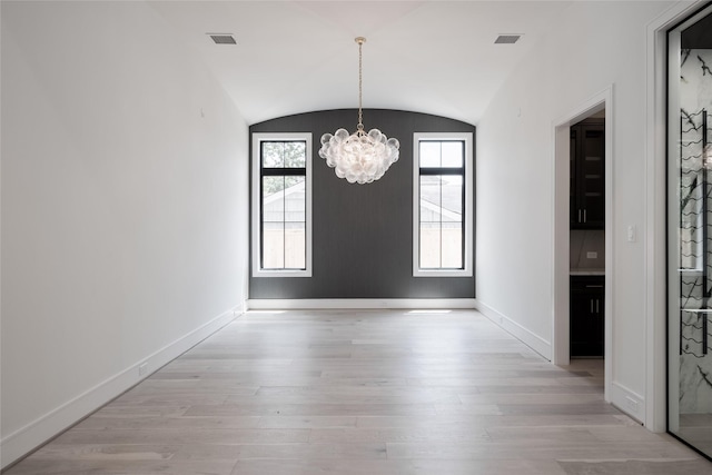 unfurnished dining area featuring plenty of natural light, light wood-type flooring, baseboards, and a notable chandelier