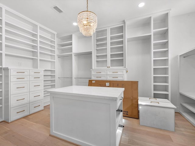 walk in closet with a chandelier, visible vents, and light wood-style flooring