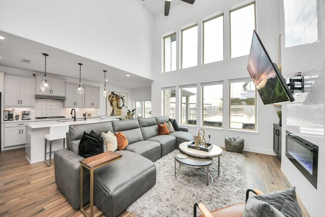 30706 Thicket Ct, Fulshear, TX 77441 - living room with a towering ceiling, a wealth of natural light, ceiling fan, and dark wood-style flooring