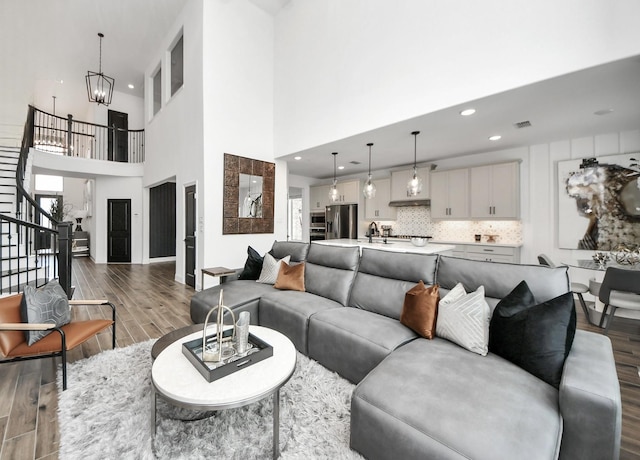30706 Thicket Ct, Fulshear, TX 77441 - living area with dark wood-style flooring, stairs, a towering ceiling, a notable chandelier, and recessed lighting
